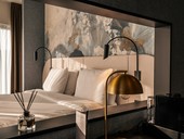Double bed with black night lights and golden floor lamp