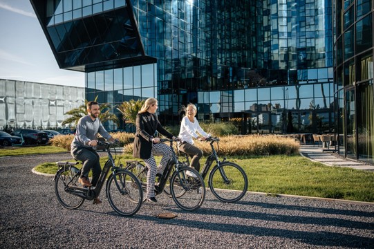Plusieurs personnes font du vélo devant l'hôtel Van der Valk à Gand.