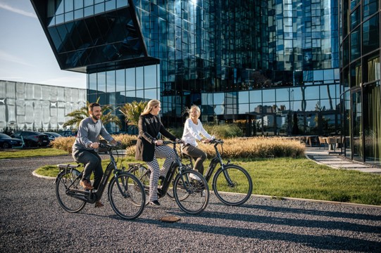 Several people cycle in front of Van der Valk Hotel Ghent