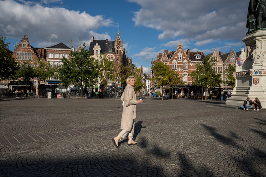 Vrouw stapt op een plein in het centrum van Gent