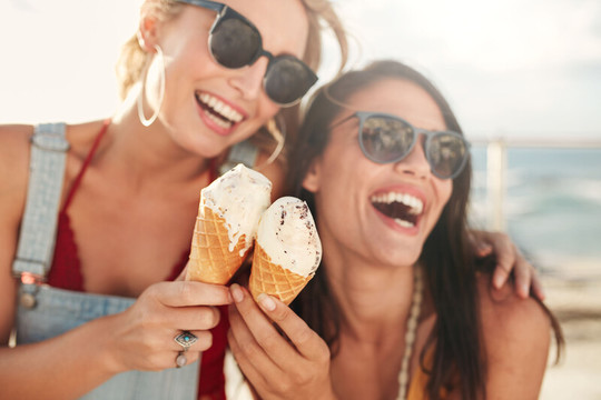 2 Frauen lachen mit Eiscreme in der Hand