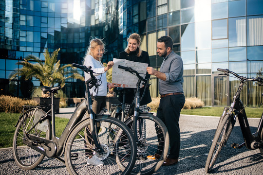 Multiple people with bikes look at a map